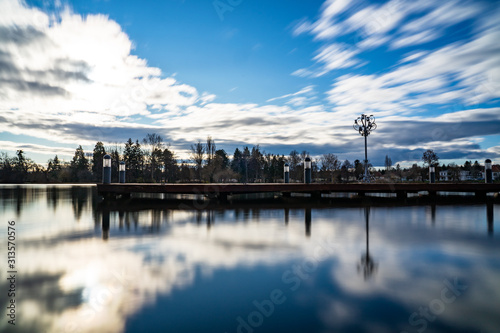 Pier deck on lake Csonakazo in Szomathely Hungary with big candle holder and dynamic sky .