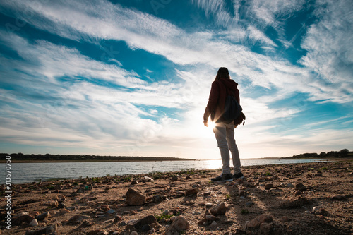 Photos Silueta de un chico al atardecer en un lago