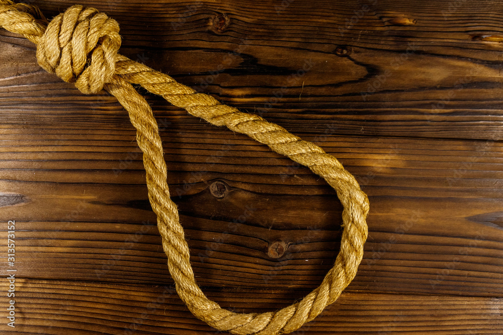 Deadly loop of rope on a wooden background. Concept of death penalty or suicide