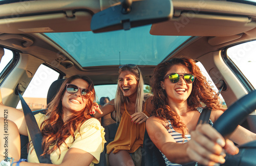 Three female friends enjoying traveling at vacation in the car. © Zoran Zeremski