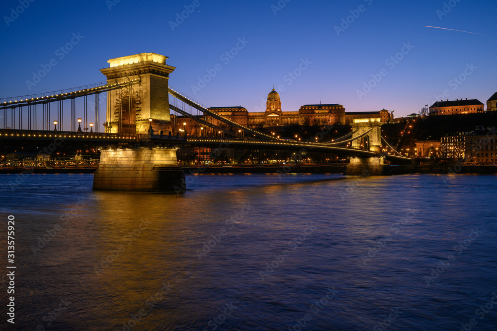 Fototapeta premium Budapest iconic Chain Bridge by night over the Danube River with the Royal Palace and the President's Palace