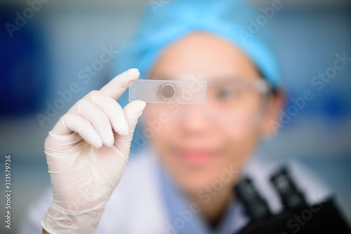 Young scientist looking through a microscope in a laboratory. Young scientist doing some research.