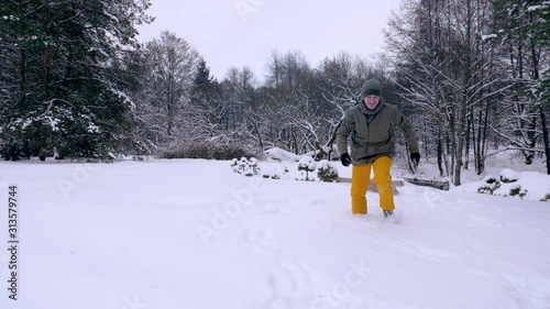 The man and his dog, the red-haired cocker spaniel, frolic in the snow. Outdoor activities in the winter during a snowfall, a man and a companion dog play together, slow motion stock video