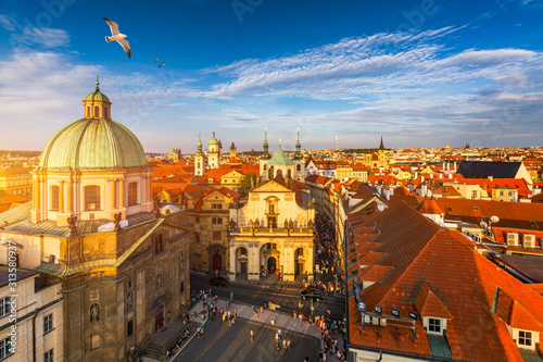 Aerial panorama view with flying birds of the Old Town in Prague, Czech Republic. Red roof tiles panorama of Prague old town. Prague Old Town Square houses with traditional red roofs. Czechia.
