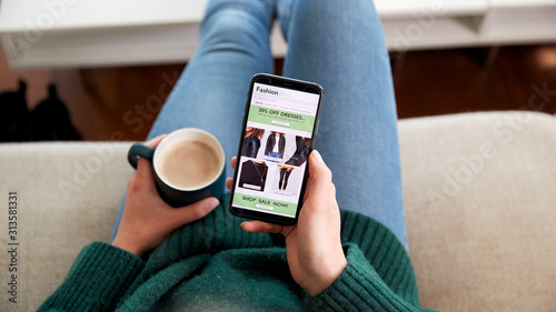 Close Up Of Woman Shopping For Clothes Online Using Mobile Phone App photo