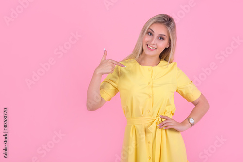 beautiful young woman in a yellow dress on a pink background