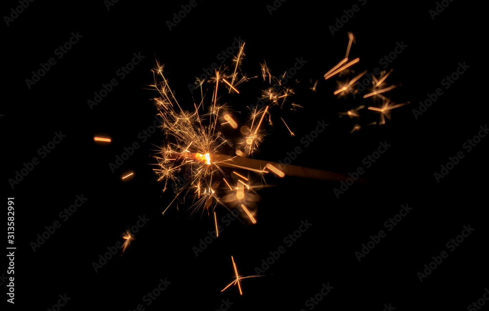 Sparklers burn in the dark, creating a festive mood. Sparklers burn in the dark, creating a festive mood.
