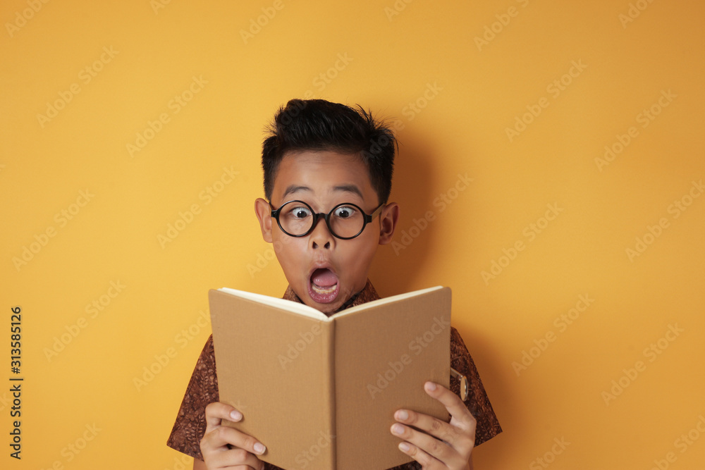 Funny Asian student boy shocked when reading book Stock Photo | Adobe Stock