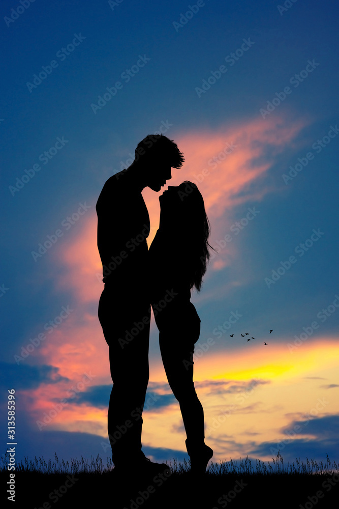 couple kissing silhouette at sunset