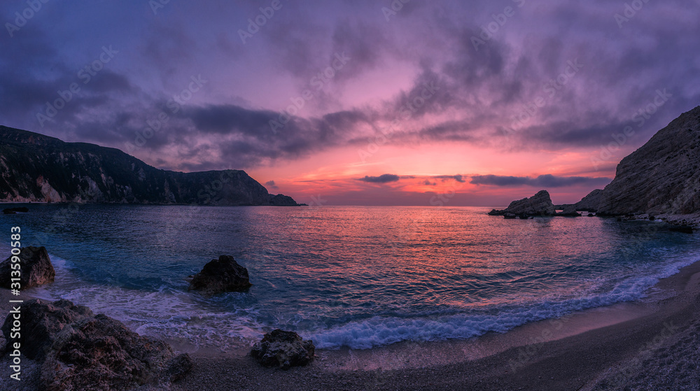 Incredible picturesque seascape during sunset, Awesome Nature Landscape. Dramatic colorful sky over the calm ocean. Landscape of Ionian Sea. Seashore with cliffs, waves crashing on rocks. Greece