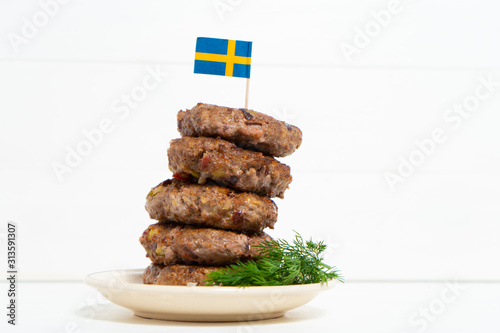 Ingredients for a traditional Swedish dish beef Lindstrom. In the plate with dill. Swedish flag.  Swedish cuisine. Scandinavian cuisine. photo