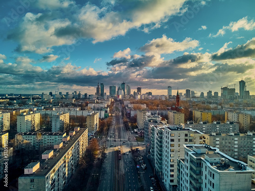 Beautiful panoramic aerial drone view to the Сenter of modern Warsaw city with silhouettes of skyscrapers in in the rays of the setting winter January sun - amazing sunset, Poland