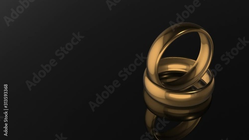 3D rendering.Two gold wedding rings on black background, loopable