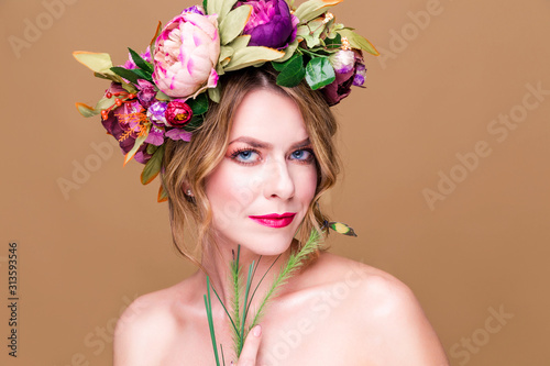 tender young womanposing in flower wreath with artificial  greenbutterfly,  isolated on ochet background photo