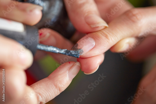 Applying manicure at nail salon 