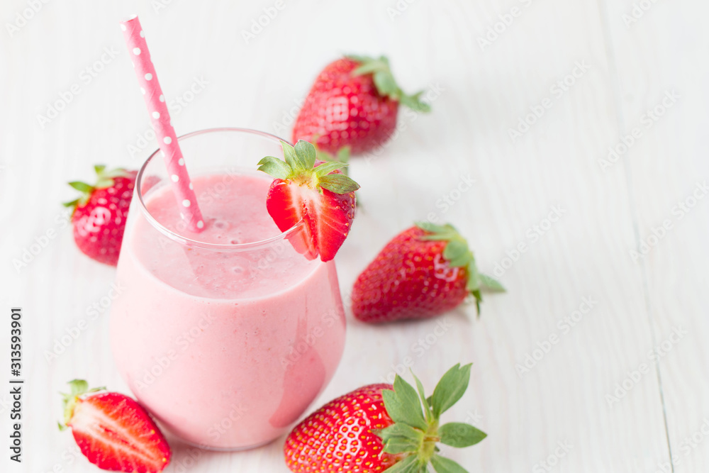 Glass of fresh strawberry milkshake, smoothie and fresh strawberries on pink, white and wooden background. Healthy food and drink concept. Glass of fresh strawberry milkshake, smoothie and fresh strawberries on pink, white and wooden background. Healthy food and drink concept.