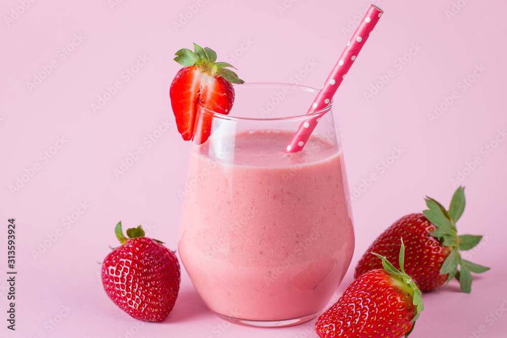 Glass of fresh strawberry milkshake, smoothie and fresh strawberries on pink, white and wooden background. Healthy food and drink concept. Glass of fresh strawberry milkshake, smoothie and fresh strawberries on pink, white and wooden background. Healthy food and drink concept.