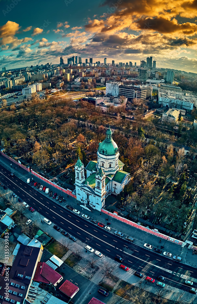 Beautiful panoramic aerial drone view to the Сenter of modern Warsaw city with silhouettes of skyscrapers and Church Karol Boromeusz (at the Powazki Cemetery) in amazing winter January sunset, Poland - obrazy, fototapety, plakaty 