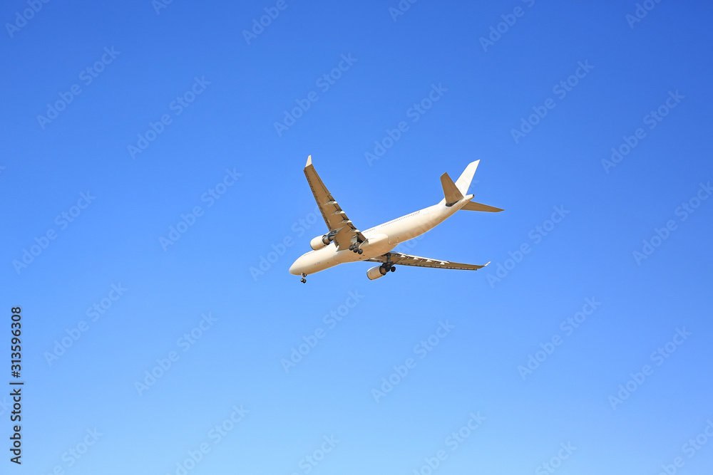 Commercial jet airplane flight on blue sky background. Seen from below. Commercial jet airplane flight on blue sky background. Seen from below.