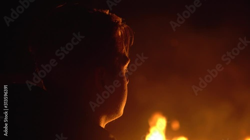 Young teenager looks at a big fire