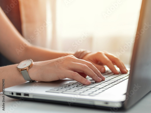 Working from home, contractor, freelance, social media, social marketing concept. Close-up woman's hands typing on laptop keyboard at home. Copy space for text or design