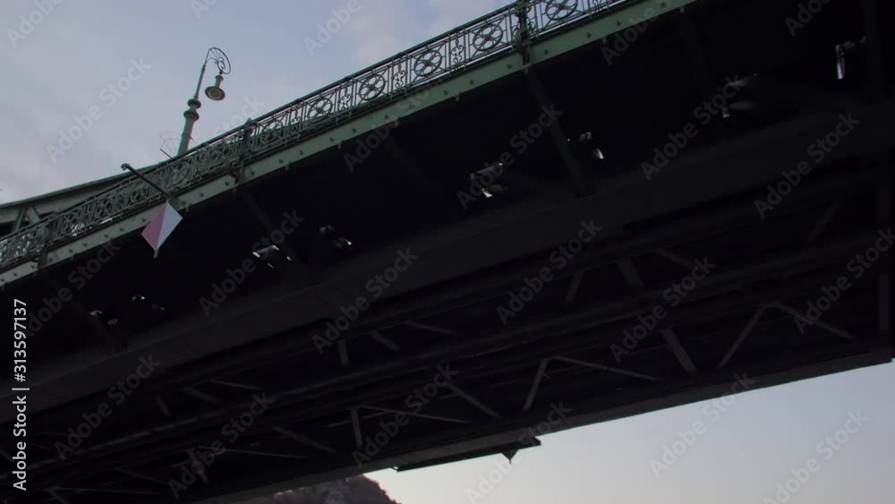 Boat departure by the river POV under the Liberty Bridge dusk evening cityscape view Elisabeth Bridge Budapest Hungary Boat departure by the river POV under the Liberty Bridge dusk evening cityscape view Elisabeth Bridge Budapest Hungary