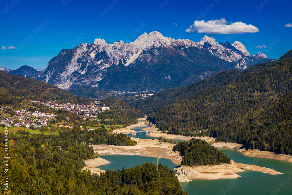 Panoramic view of lake of Centro Cadore in the Alps in Italy, Dolomites, near Belluno. View of Lake Calalzo, Belluno, Italy. Lake of Centro Cadore in the Alps in Italy, near Belluno.