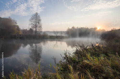 River bank in the morning in the fall with fog.