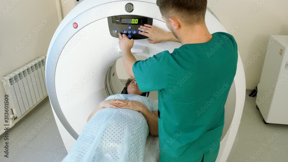 Aged female patient is undergoing MRI or CT scan under supervision of a radiologist in modern medical clinic. 4K Aged female patient is undergoing MRI or CT scan under supervision of a radiologist in modern medical clinic. 4K