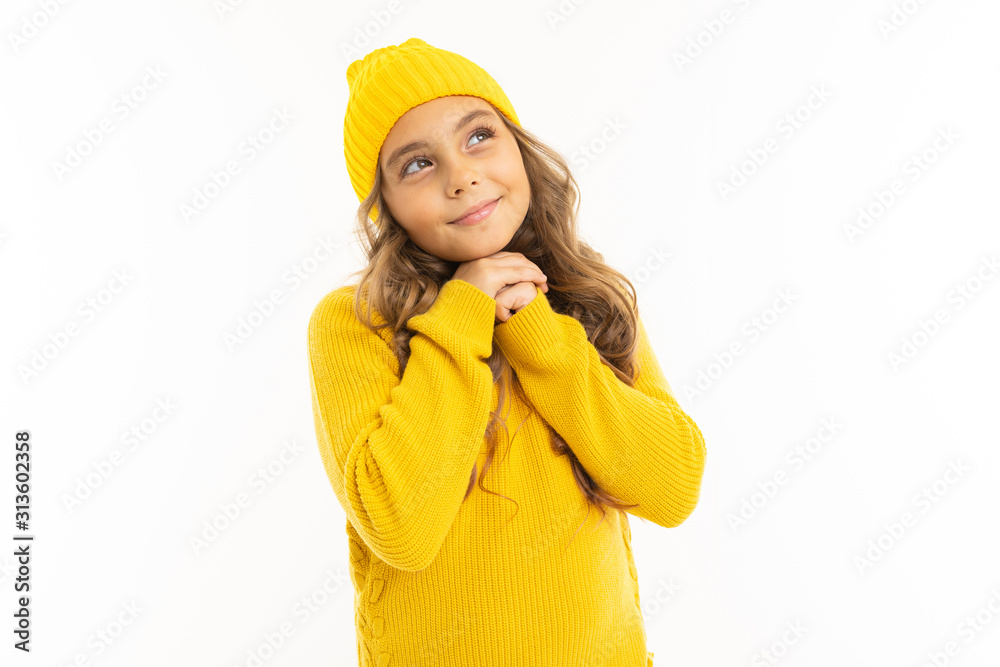 Little girl with in yellow hoody and hat dreams, portrait isolated on white background Little girl with in yellow hoody and hat dreams, portrait isolated on white background