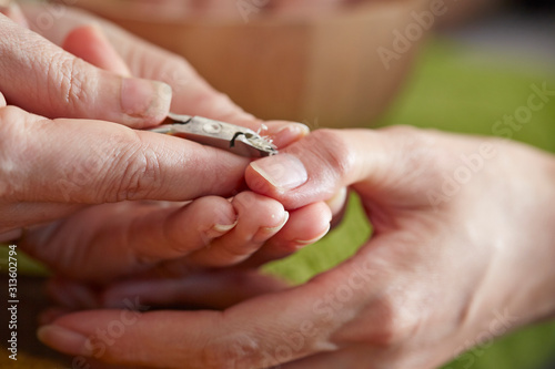 Nail care service at salon  removing cuticle with nail nipper 