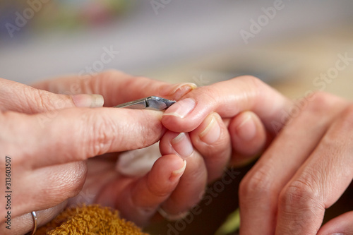 Nail care service at salon  removing cuticle with nail nipper 