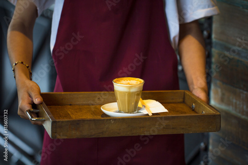 Coffee Business Concept - barista waitress offers white hot coffee cup serving to customer at coffee shop, Closeup.
