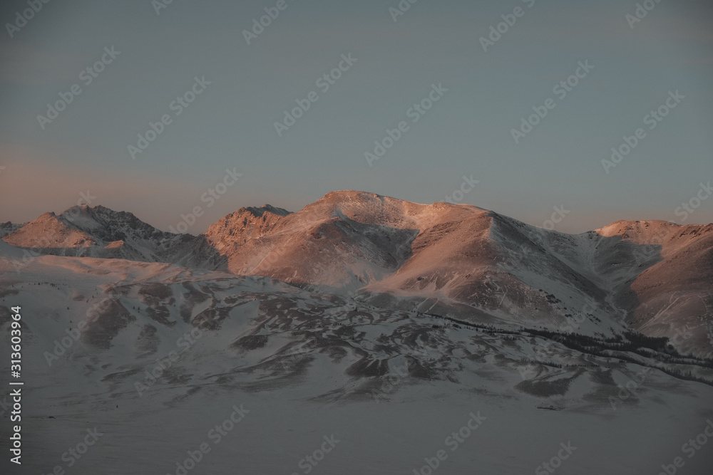 mountain range under white snow and ice at dawn