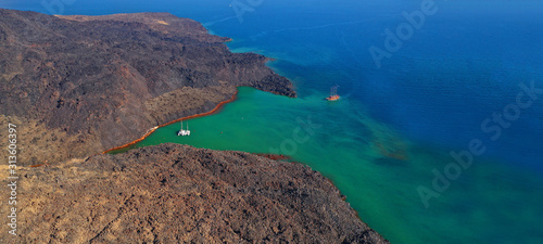 Aerial drone ultra wide photo of famous volcanic crater of Palaia Kameni with green sea in centre of Santorini island  Cyclades  Greece