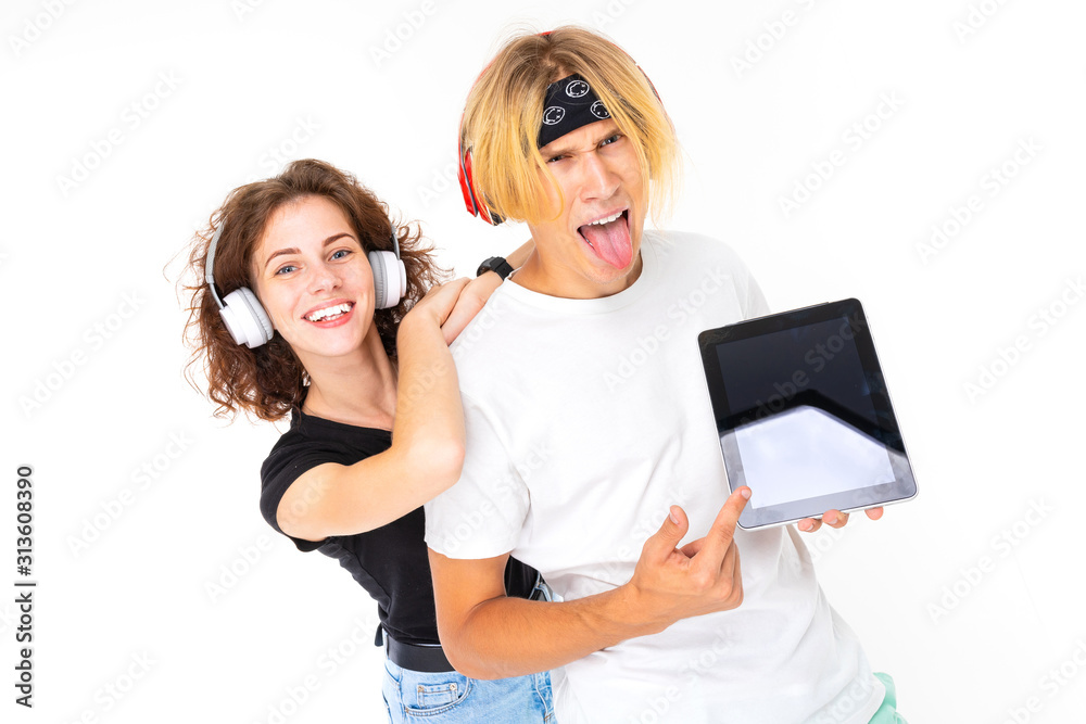 girl in headphones leans on a guy blond holding a tablet with a mockup on a white background girl in headphones leans on a guy blond holding a tablet with a mockup on a white background