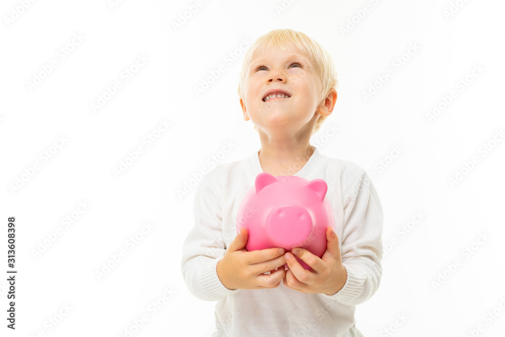 portrait of a charming cute blond boy holding a piggy bank on a white background with copy space portrait of a charming cute blond boy holding a piggy bank on a white background with copy space