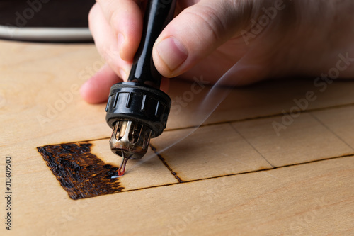 Pyrography. Wood burning with pyrography pen. Close up