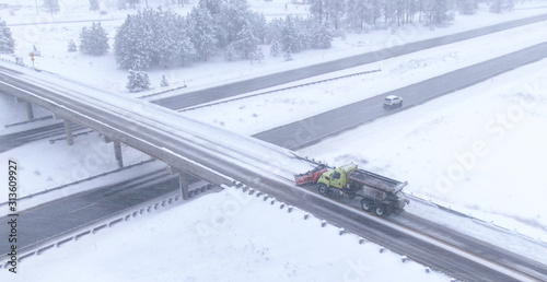AERIAL: Snowplow cleans the highway overpass during a snowstorm in Washington