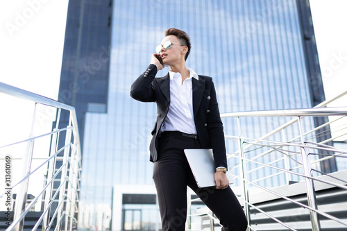 business woman with notepad on the background of a modern high-rise building