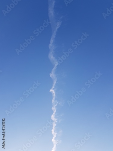 Inversion trail of an airplane in the blue sky