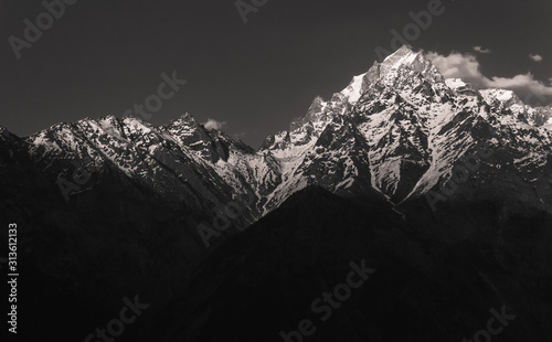 A black and white shot of the evening light hitting the Kinner Kailash peaks in the village of Kalpa in Kinnaur in the Indian Himalaya. photo