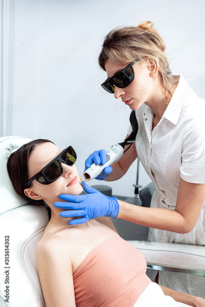 Skin Care. Young Woman Receiving Facial Beauty Treatment, Removing Pigmentation At Cosmetic Clinic. Intense Pulsed Light Therapy. IPL. Rejuvenation, Photo Facial Therapy. Anti-aging Procedures. Skin Care. Young Woman Receiving Facial Beauty Treatment, Removing Pigmentation At Cosmetic Clinic. Intense Pulsed Light Therapy. IPL. Rejuvenation, Photo Facial Therapy. Anti-aging Procedures.