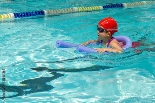 kid learn how to swim in swimming class