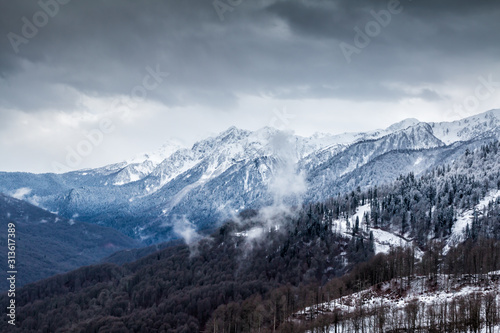 High mountain peaks covered with snow on a winter cloudy day