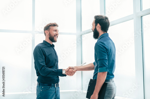 smiling business people shaking hands in the office.