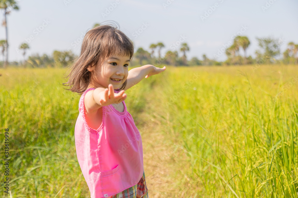 A lovely Thai girl, about three and a half years old in the traditional cloth, is playing happily on the rice field, and it can only be found in the countryside. A lovely Thai girl, about three and a half years old in the traditional cloth, is playing happily on the rice field, and it can only be found in the countryside.