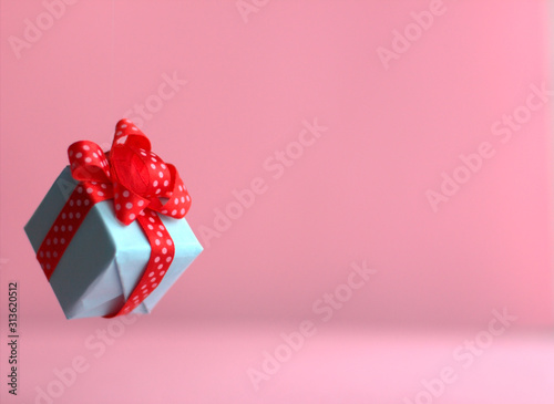 Gift box with red ribbon trendy pink color background. zero gravity. levitation. copyspace. Concept sales, discount price, presents, shopping.
