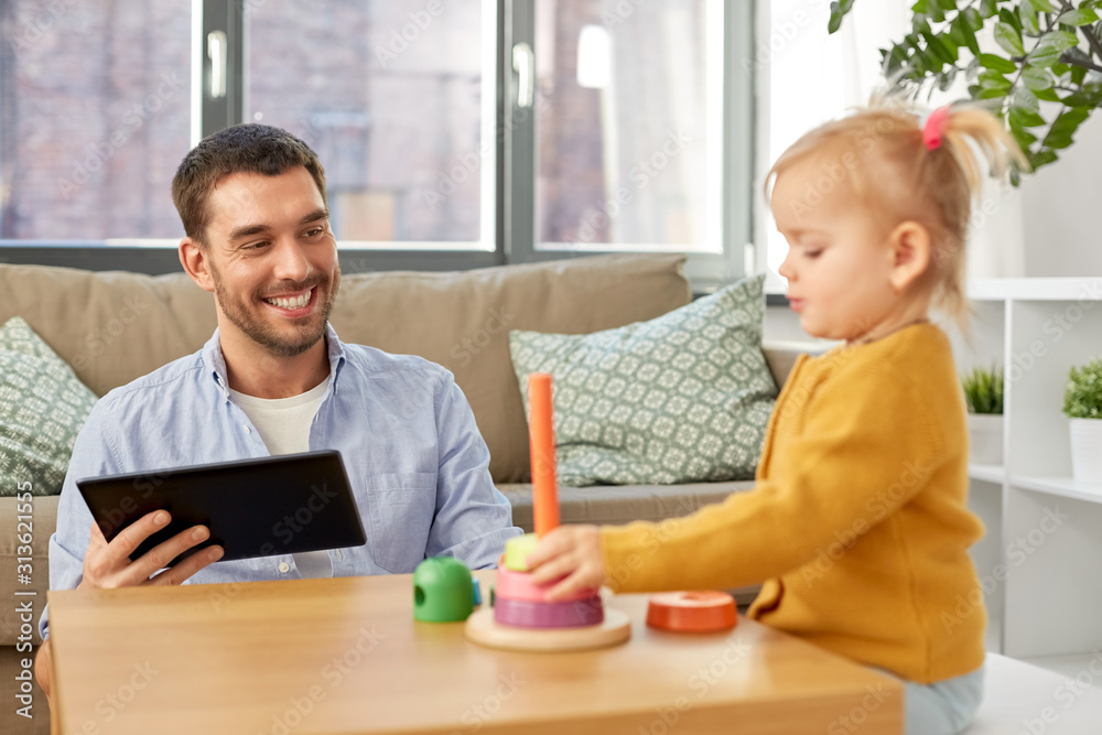 family, fatherhood and people concept - happy father with tablet pc computer and little baby daughter playing with pyramid toy at home family, fatherhood and people concept - happy father with tablet pc computer and little baby daughter playing with pyramid toy at home