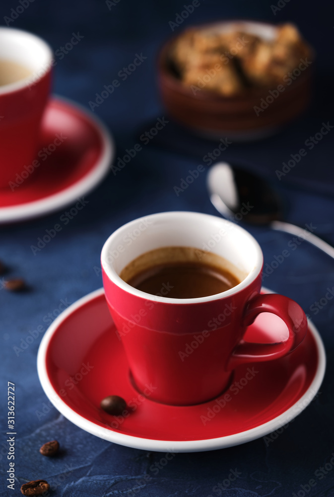 Red Mug of aromatic espresso on a blue table. Red Mug of aromatic espresso on a blue table.
